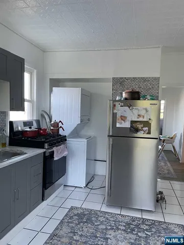 a kitchen with stainless steel appliances granite countertop a refrigerator a stove a sink and a counter