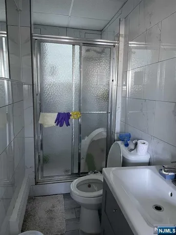 a bathroom with a granite countertop sink a toilet and shower