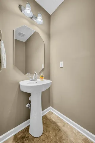 a bathroom with a sink toilet and a mirror