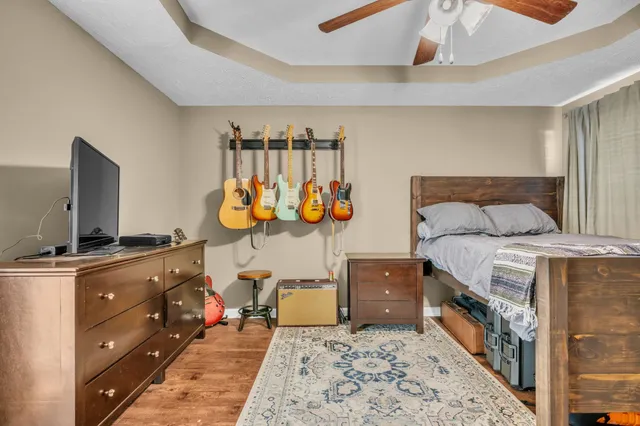 a bedroom with a bed and a flat tv screen on dresser