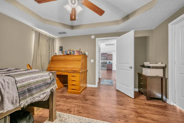 a bedroom with a bed and wooden floor