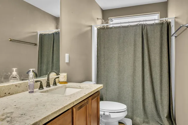 a bathroom with a granite countertop sink toilet and shower