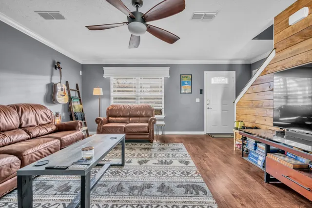 a living room with furniture and a wooden floor