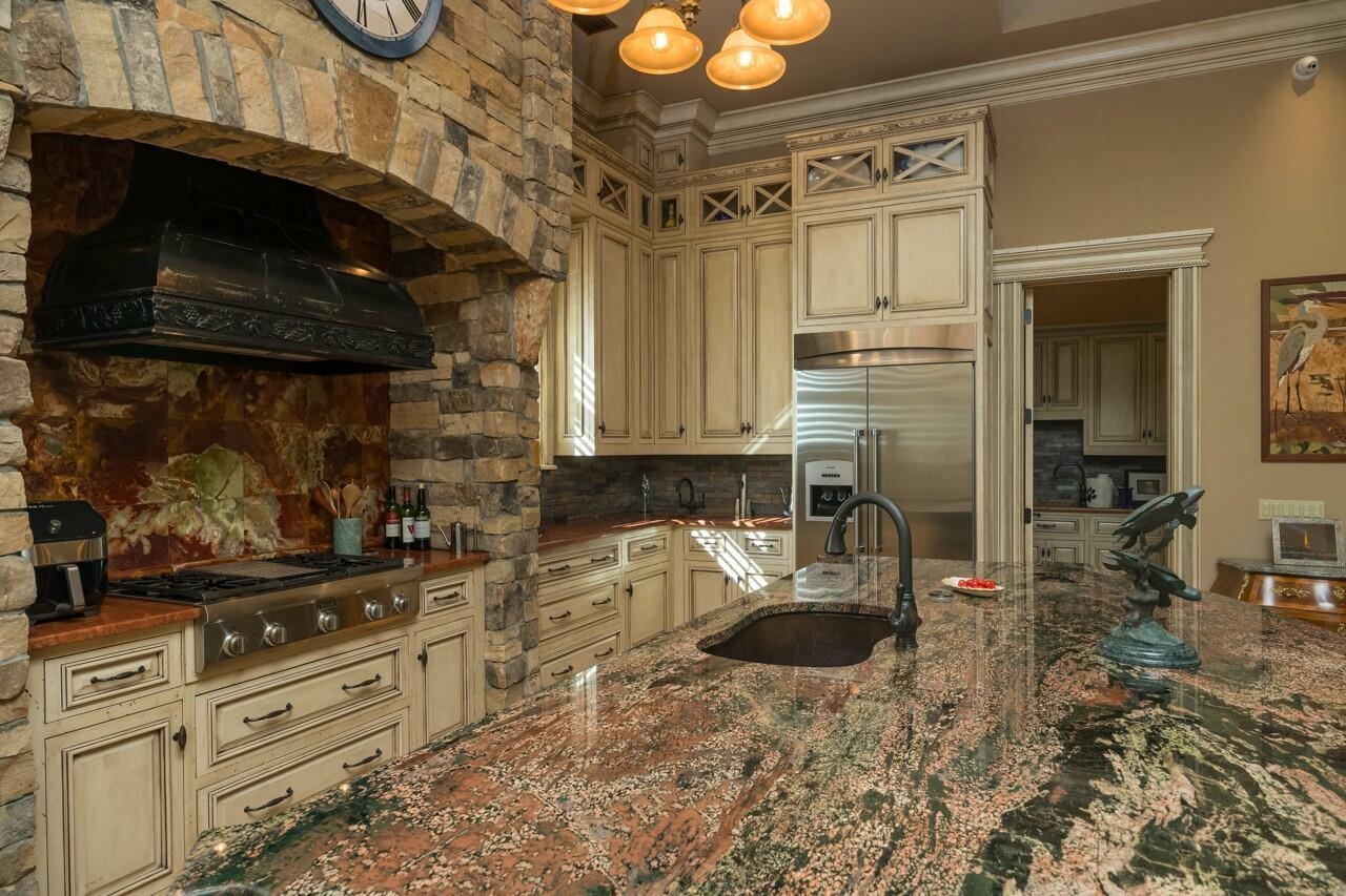 924 Ocean Palm Way St. Augustine, FL 32080 - Photo 22 of 81 a kitchen with granite countertop a sink a stove and cabinets