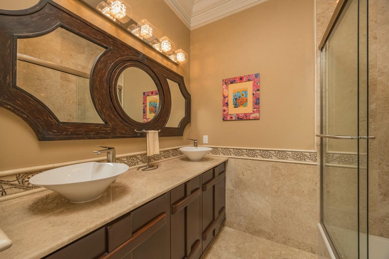 924 Ocean Palm Way St. Augustine, FL 32080 - Photo 48 of 81 a bathroom with a granite countertop sink a mirror and a shower
