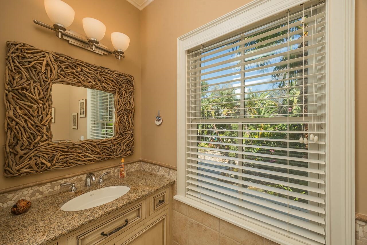 924 Ocean Palm Way St. Augustine, FL 32080 - Photo 62 of 81 a bathroom with a granite countertop sink a mirror and shower