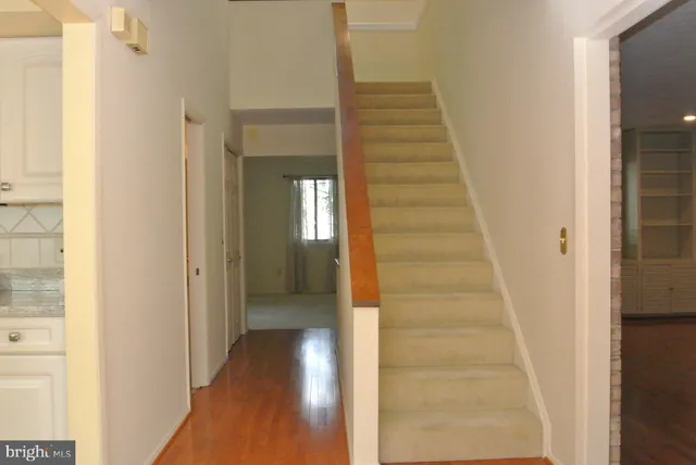 a view of a hallway with wooden floor and entryway
