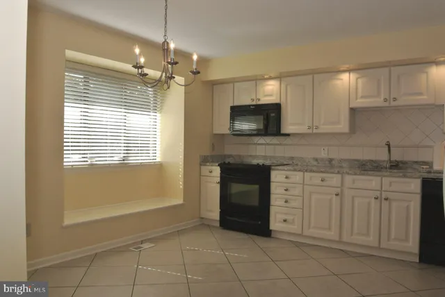 a kitchen with kitchen island granite countertop a sink window and cabinets