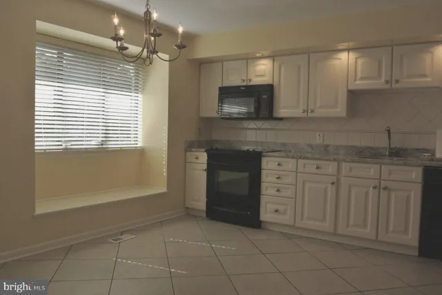 a kitchen with cabinets appliances and a window