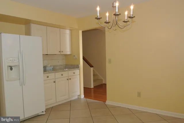 a room with white cabinets and chandelier