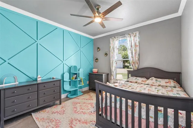 a bedroom with a bed a chandelier and a dresser