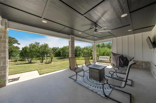 a view of a patio with table and chairs and couches with wooden floor