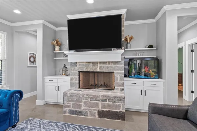 a living room with furniture a flat screen tv and a fireplace