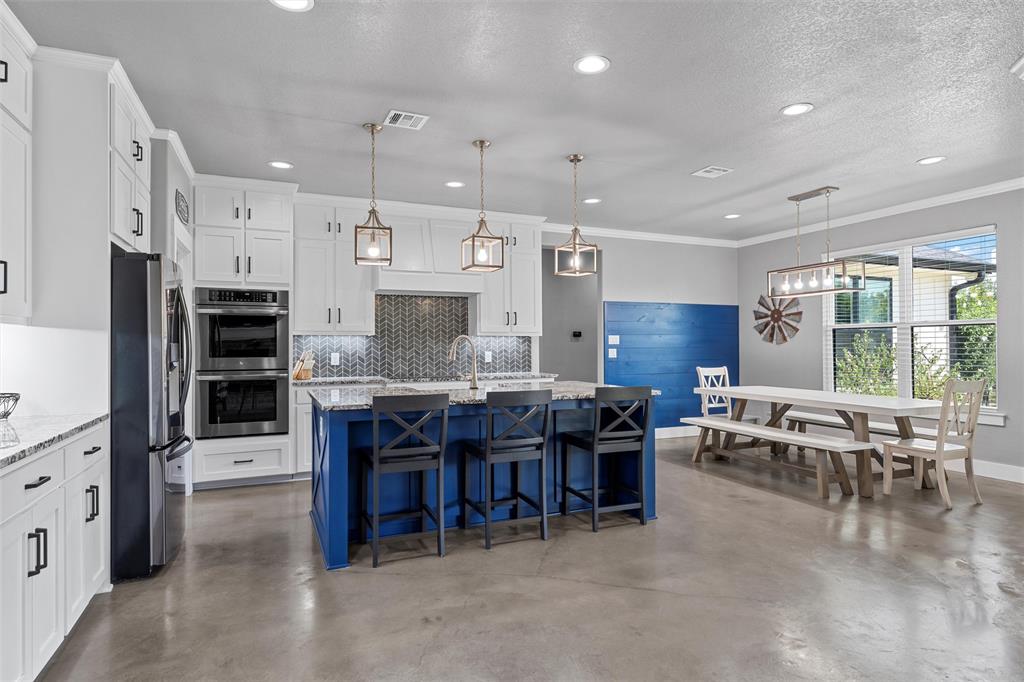 370 Rio Bonito Drive Robinson, TX 76706 - Photo 9 of 39 a kitchen with stainless steel appliances kitchen island granite countertop a table chairs sink and cabinets
