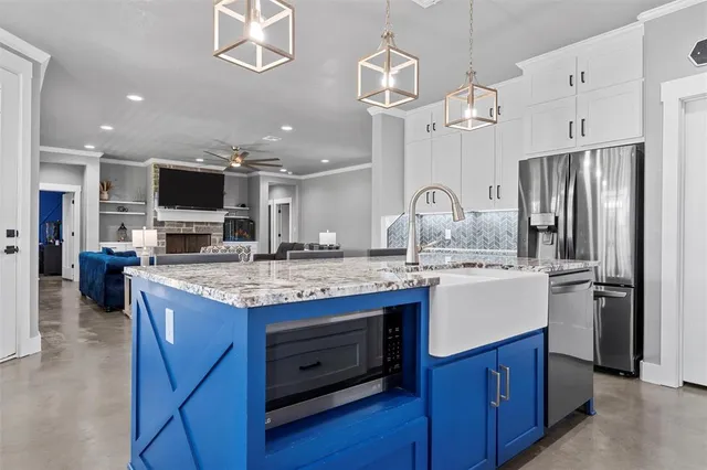 a kitchen with kitchen island granite countertop a sink appliances and cabinets