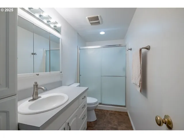 a bathroom with a sink toilet a mirror and shower