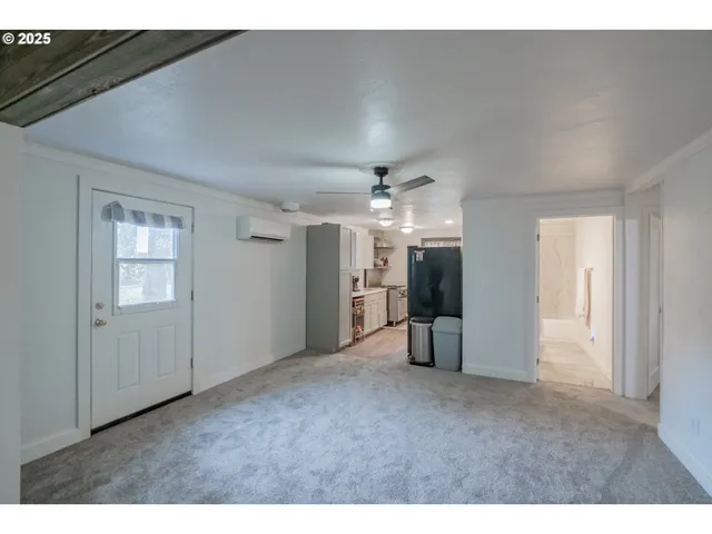 a view of a big room with windows and chandelier fan