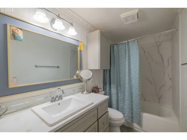 a bathroom with a sink mirror vanity and toilet