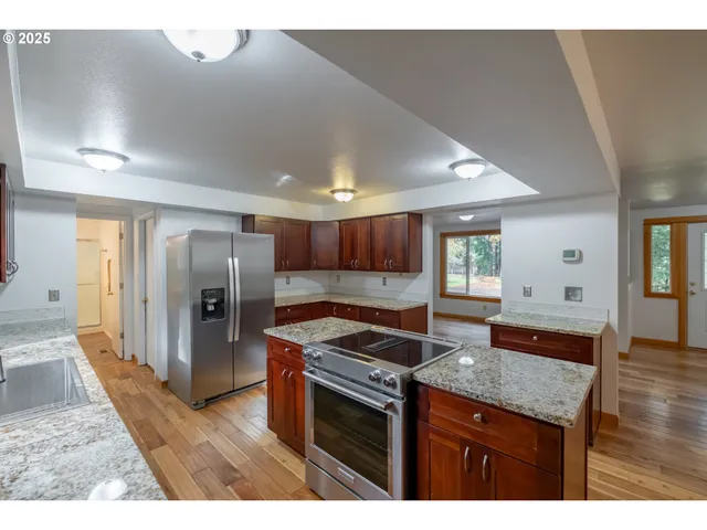 a kitchen with stainless steel appliances granite countertop a sink stove and refrigerator