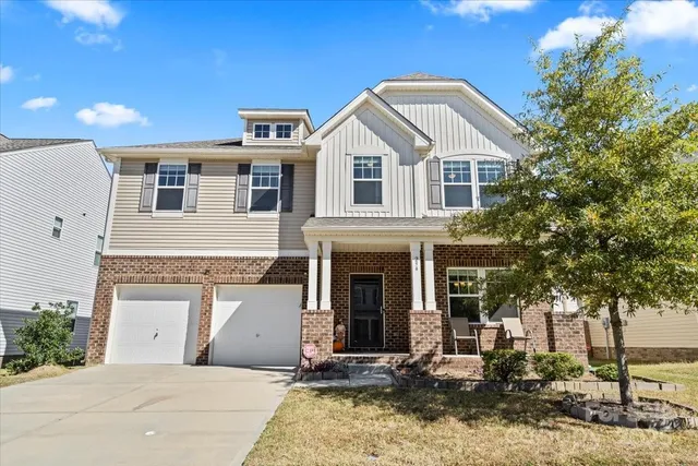 a view of a white house with large windows and a small yard