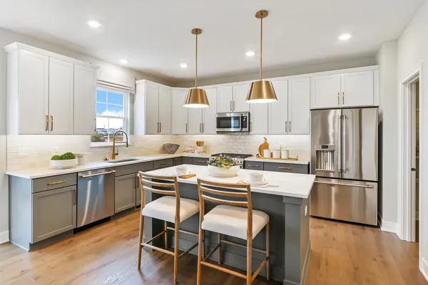 a kitchen with kitchen island white cabinets and stainless steel appliances