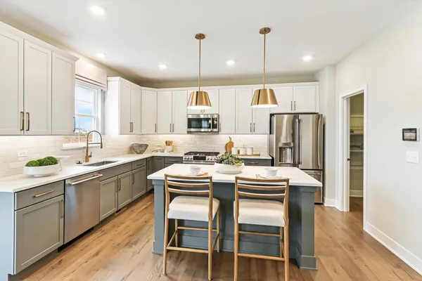 a kitchen with kitchen island white cabinets and stainless steel appliances