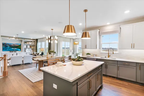 a kitchen with a sink stove and wooden floor