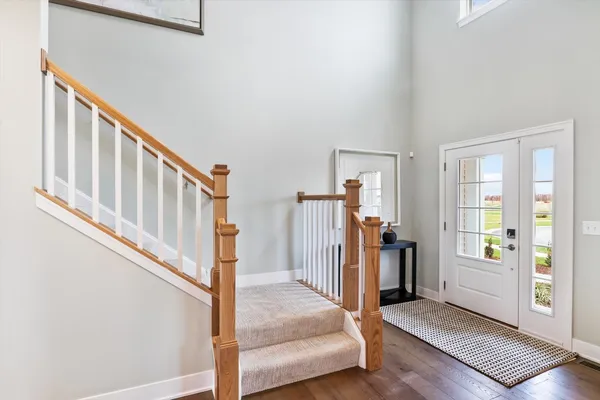 a view of a livingroom with wooden floor and stairs