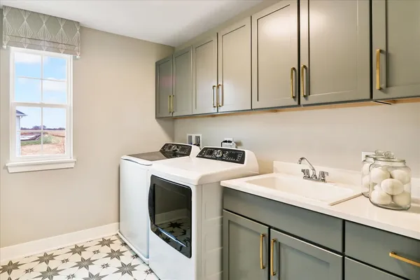a utility room with sink dryer and washer