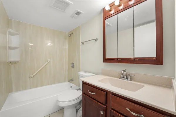 a bathroom with a sink a toilet and a large mirror