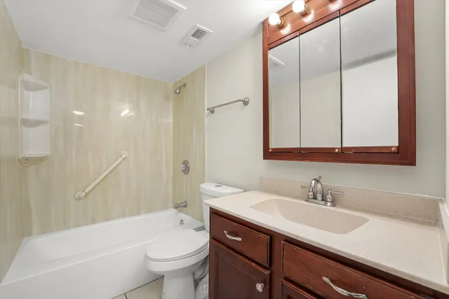 a bathroom with a sink a toilet and a large mirror