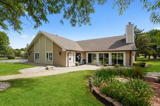 a front view of a house with a garden and yard
