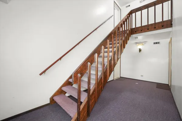 a view of staircase with wooden floor and white walls