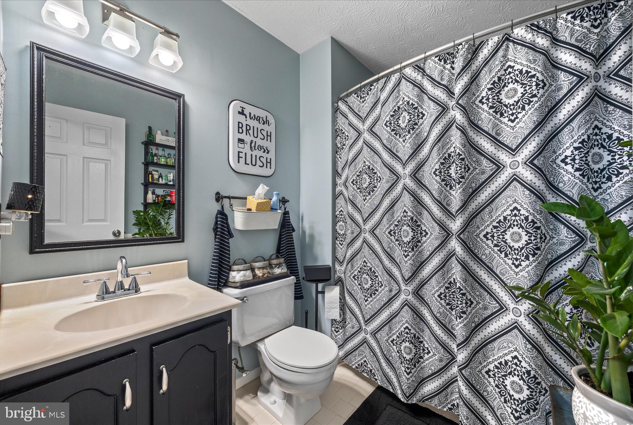 7914 Leeds Drive Pasadena, MD 21122 - Photo 23 of 49 a bathroom with a toilet sink and mirror