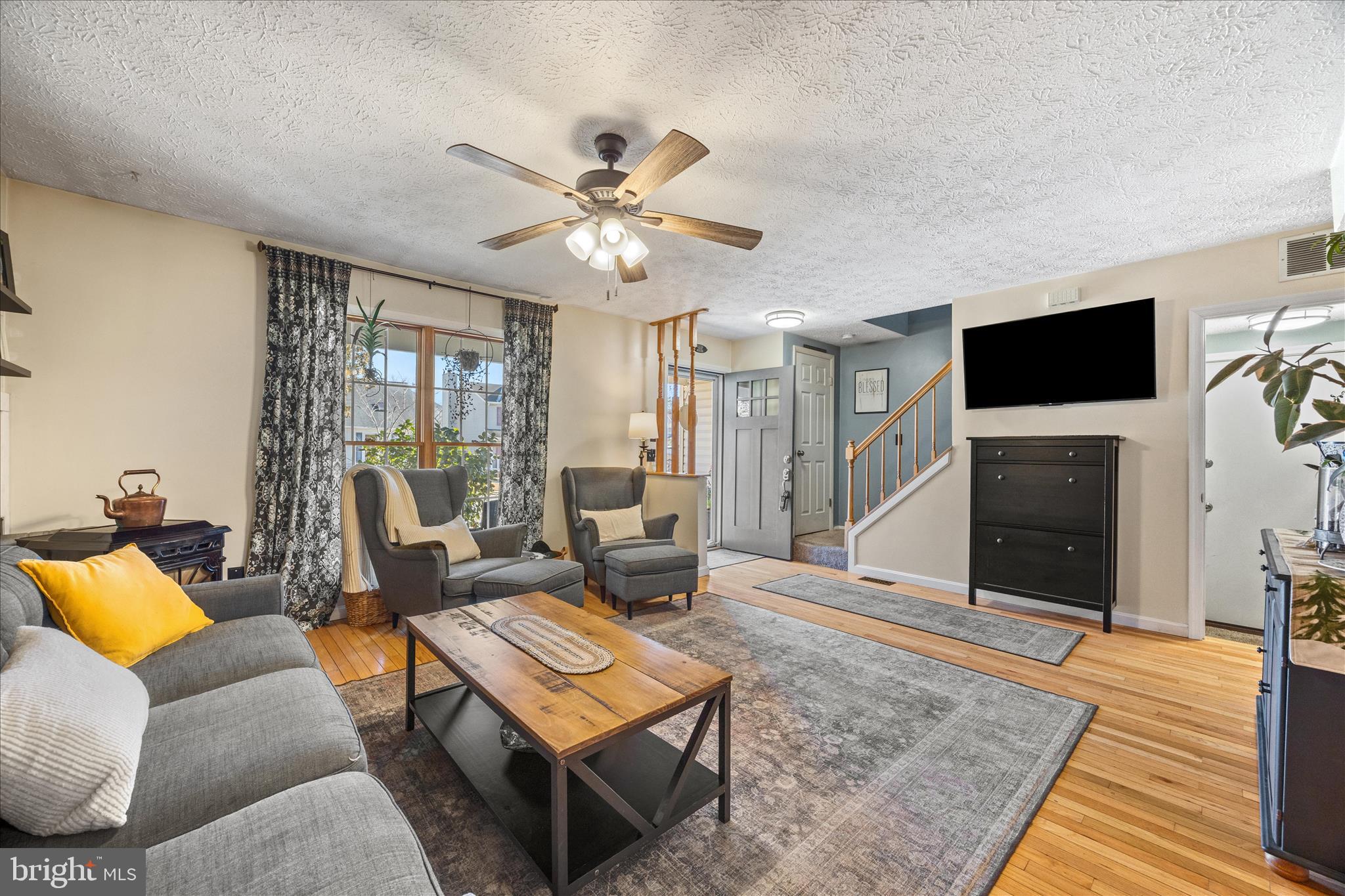 7914 Leeds Drive Pasadena, MD 21122 - Photo 7 of 49 a living room with furniture a fireplace and a flat screen tv