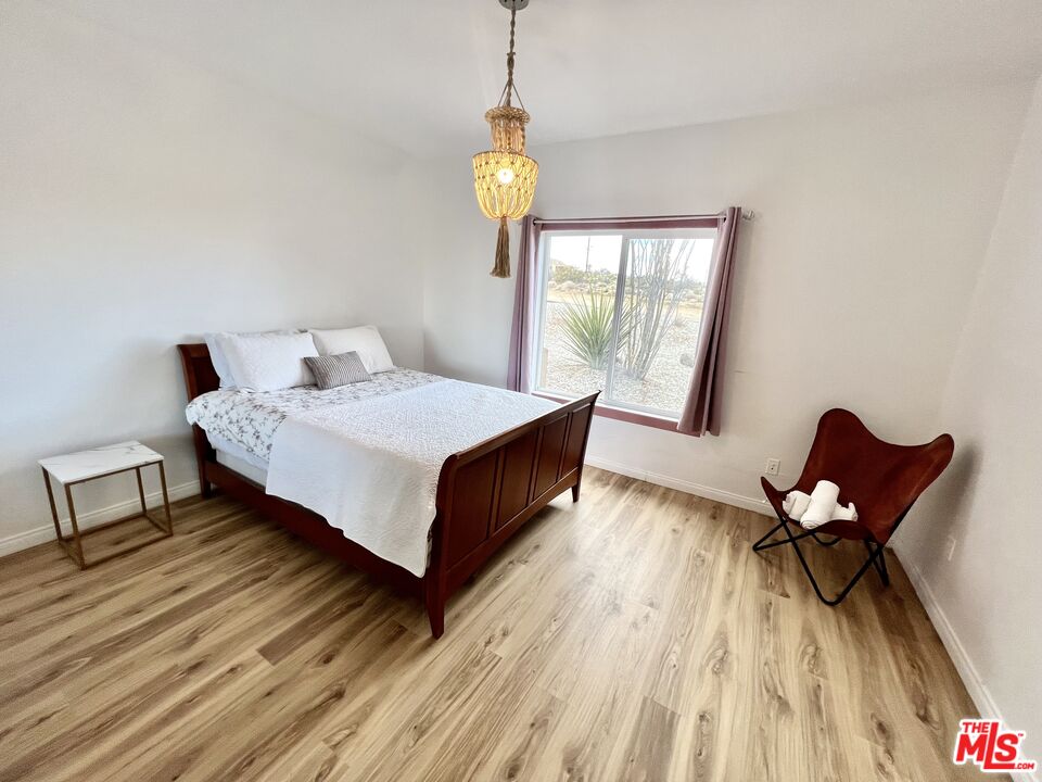 7285 Agave Road Joshua Tree, CA 92252 - Photo 12 of 18 a bedroom with a bed a chair and a window