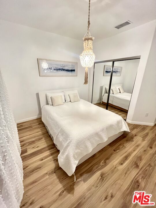 7285 Agave Road Joshua Tree, CA 92252 - Photo 13 of 18 a bedroom with a bed and wooden floor