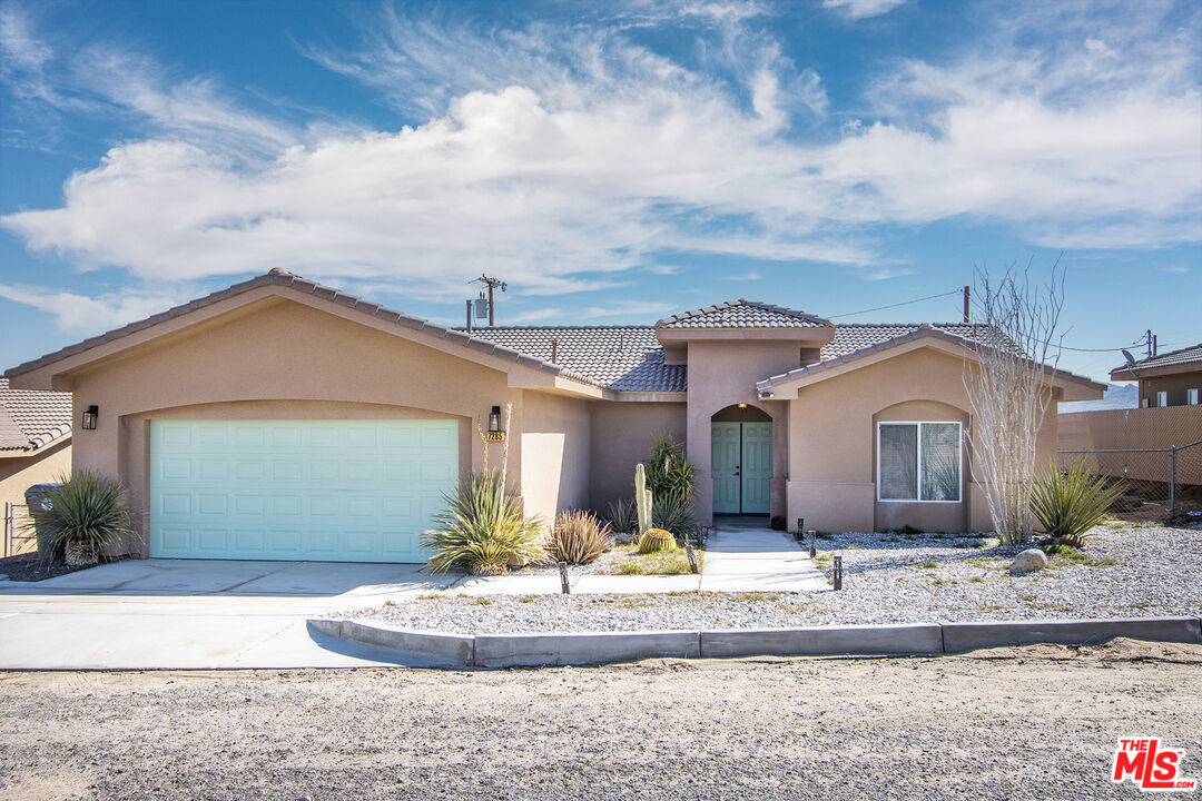 7285 Agave Road Joshua Tree, CA 92252 - Photo 18 of 18 a front view of a house with a yard and garage