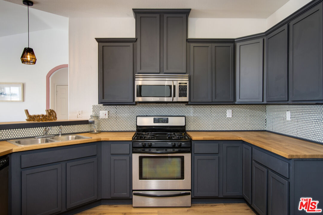 7285 Agave Road Joshua Tree, CA 92252 - Photo 5 of 18 a kitchen with stainless steel appliances wooden cabinets and a stove top oven