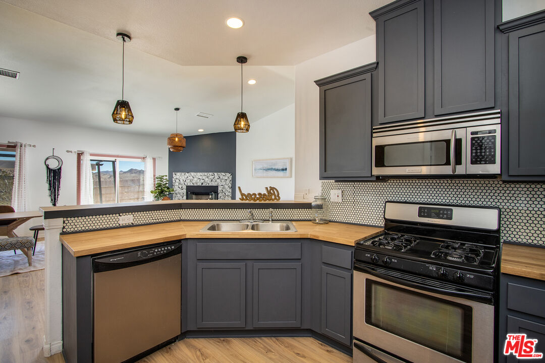 7285 Agave Road Joshua Tree, CA 92252 - Photo 7 of 18 a kitchen with stainless steel appliances a stove sink and microwave