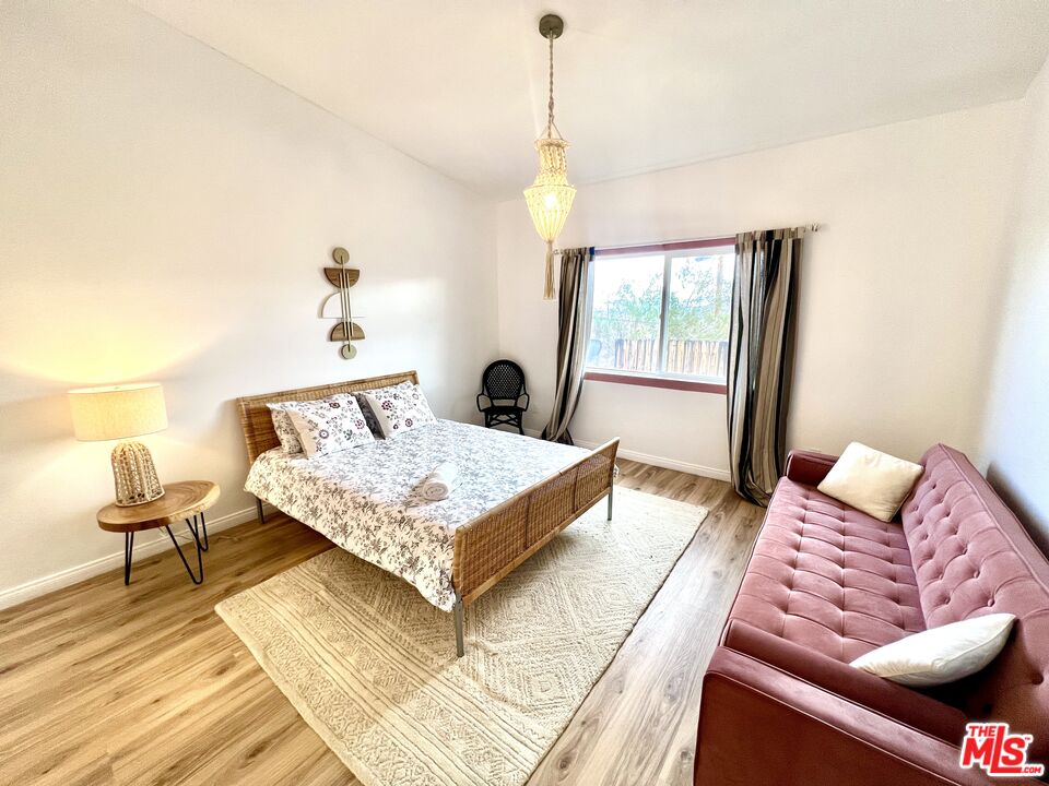 7285 Agave Road Joshua Tree, CA 92252 - Photo 8 of 18 a bedroom with a bed and wooden floor