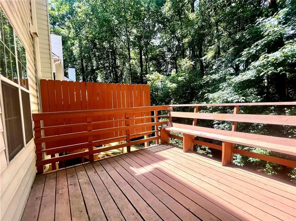a view of a balcony with wooden floor and fence