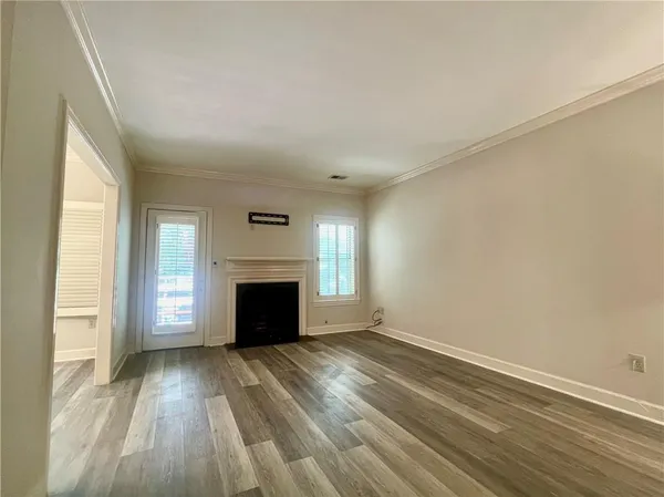 an empty room with windows and fireplace