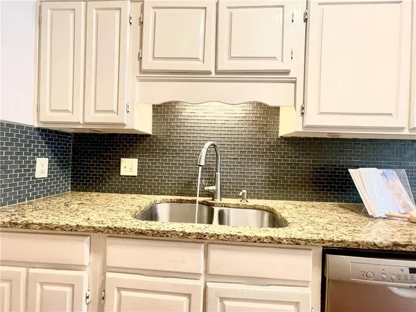 a kitchen with granite countertop a sink and cabinets