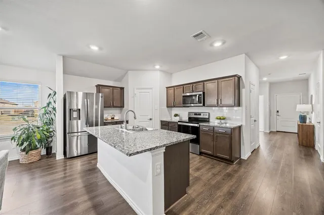 a large kitchen with a center island and stainless steel appliances