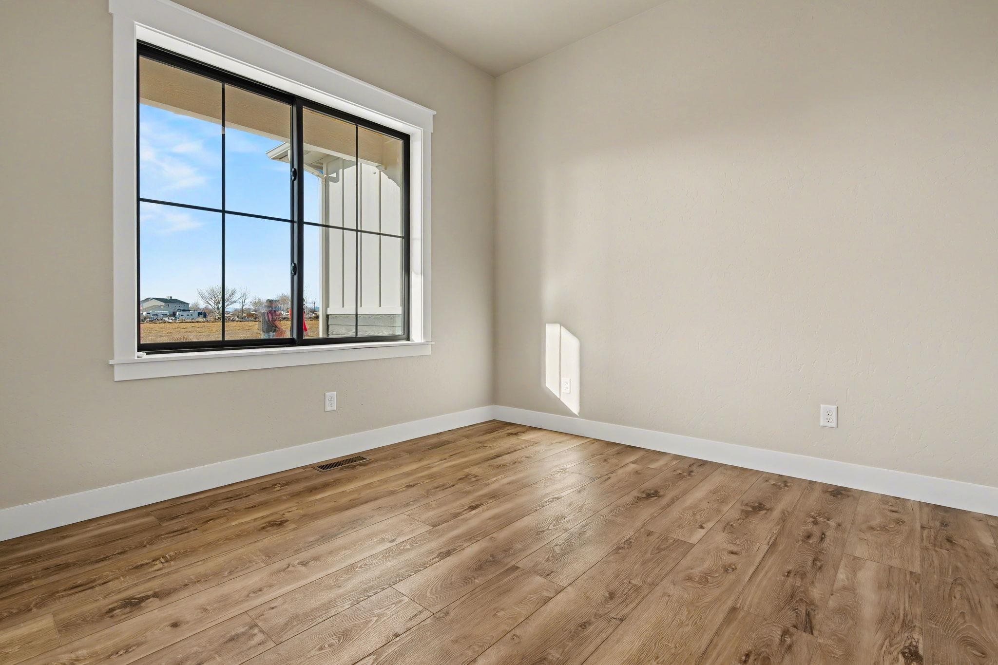 1924 K Road Fruita, CO 81521 - Photo 17 of 40 an empty room with wooden floor and windows