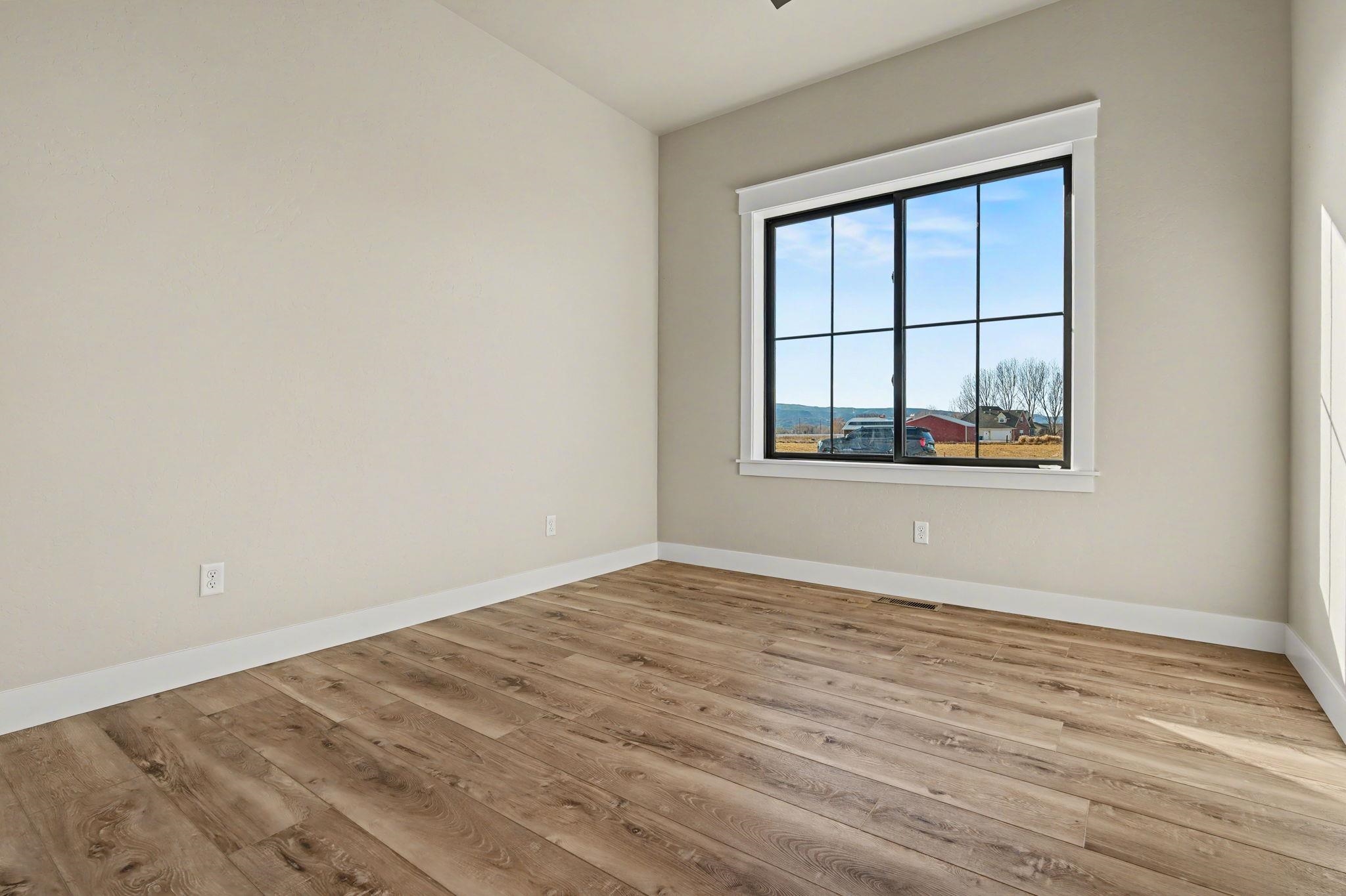 1924 K Road Fruita, CO 81521 - Photo 21 of 40 a view of an empty room with wooden floor and a window