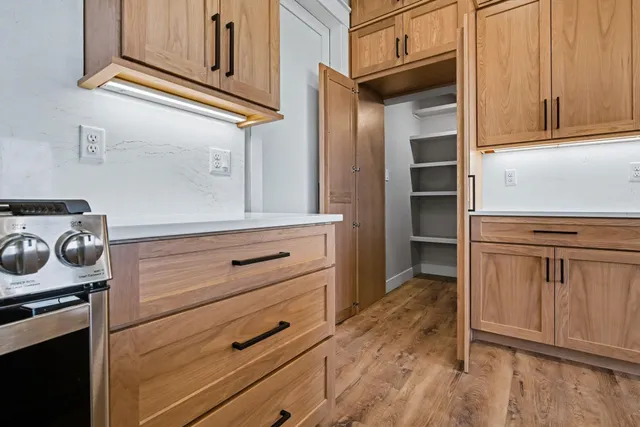 a kitchen with white cabinets and a stove top oven