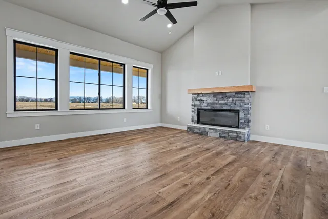 wooden floor fireplace and windows in an empty room