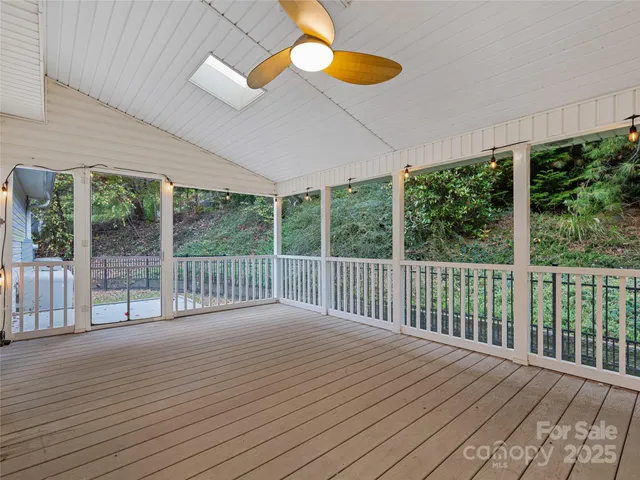 an empty room with windows and ceiling fan